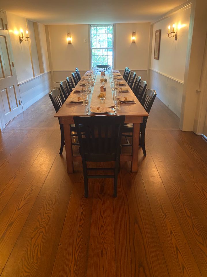 a long table with chairs and plates on it