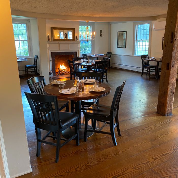 a room with a fireplace and tables