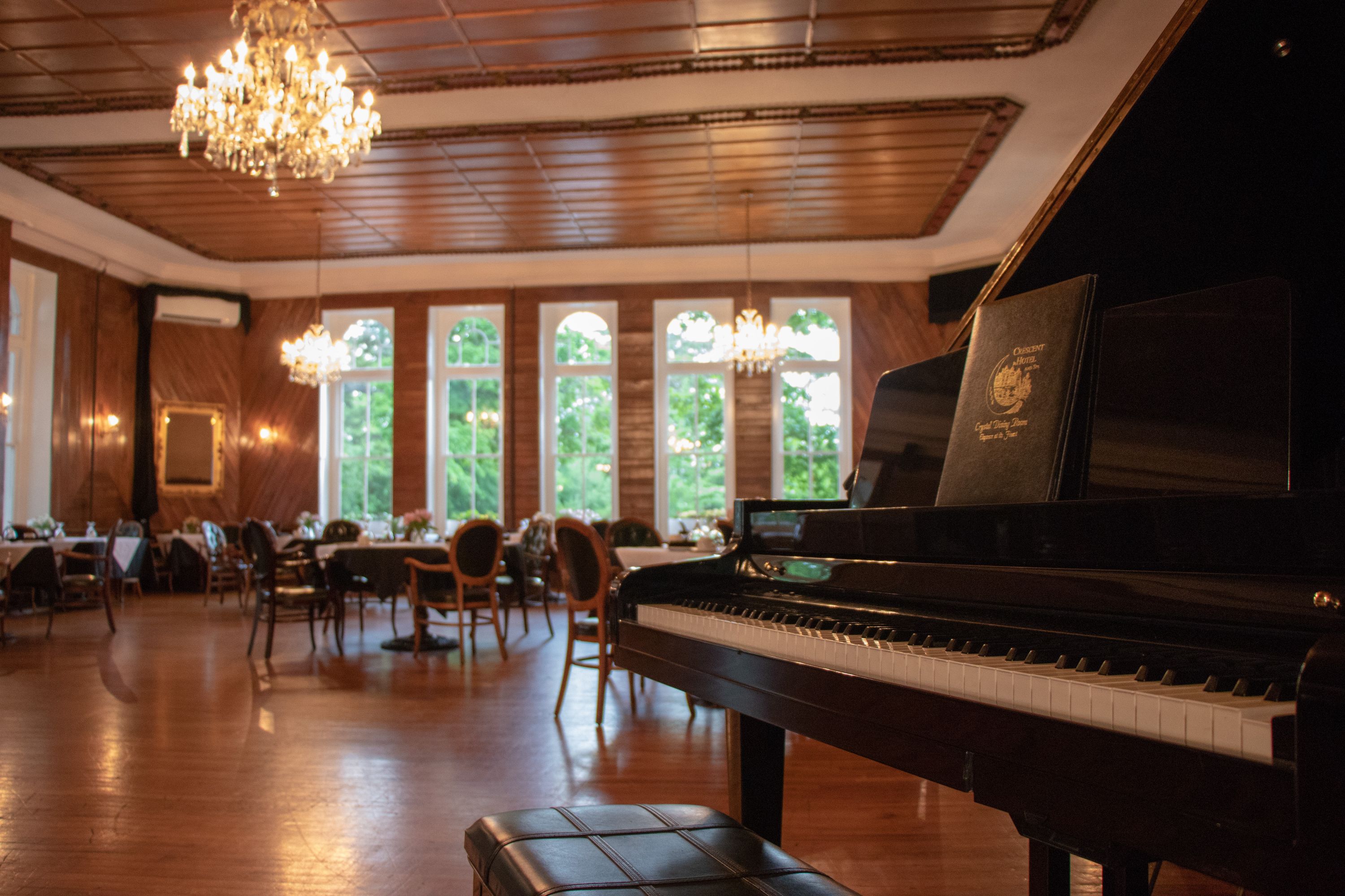 a piano in a room with tables and chairs