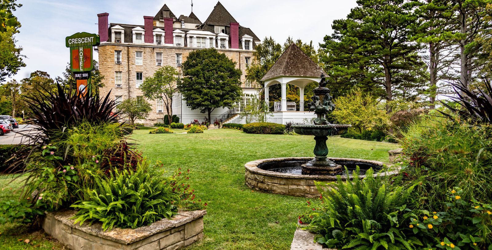 a fountain in a park with a gazebo in the background