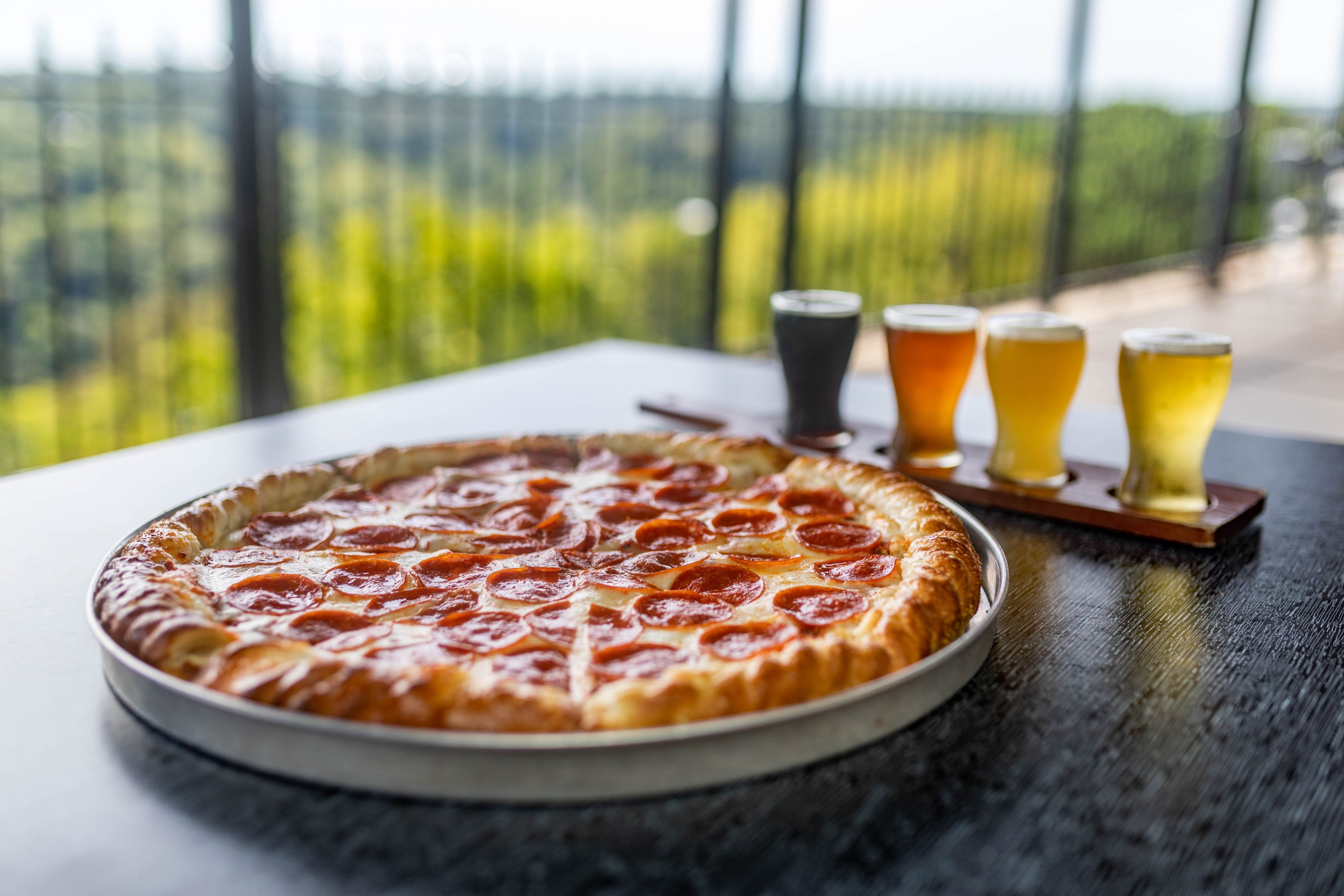 a pizza and beer glasses on a table