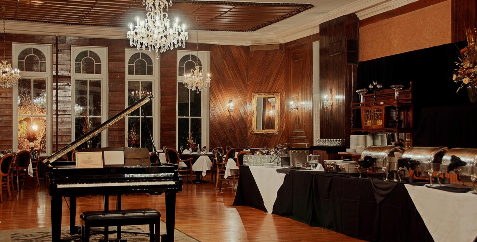 a room with a piano and a chandelier
