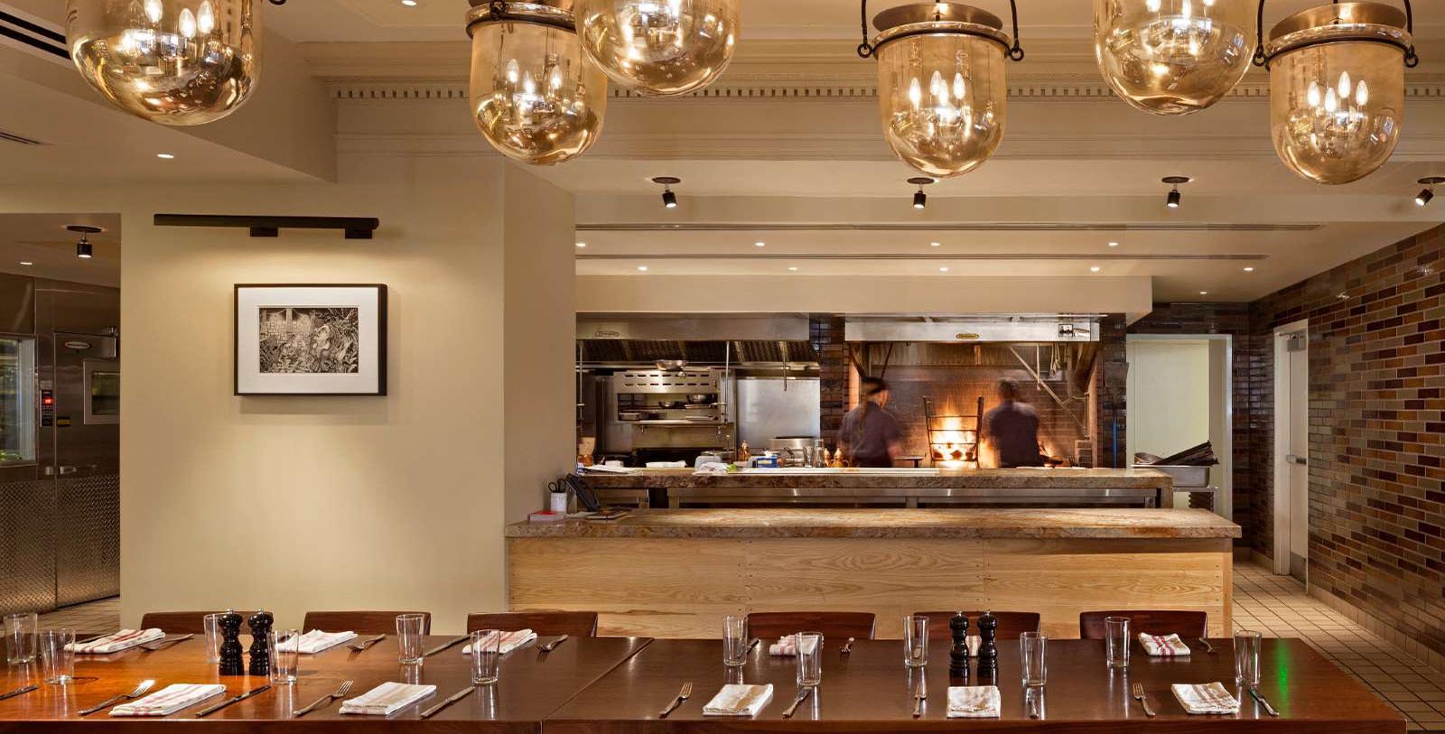 a restaurant with a chef cooking in the background