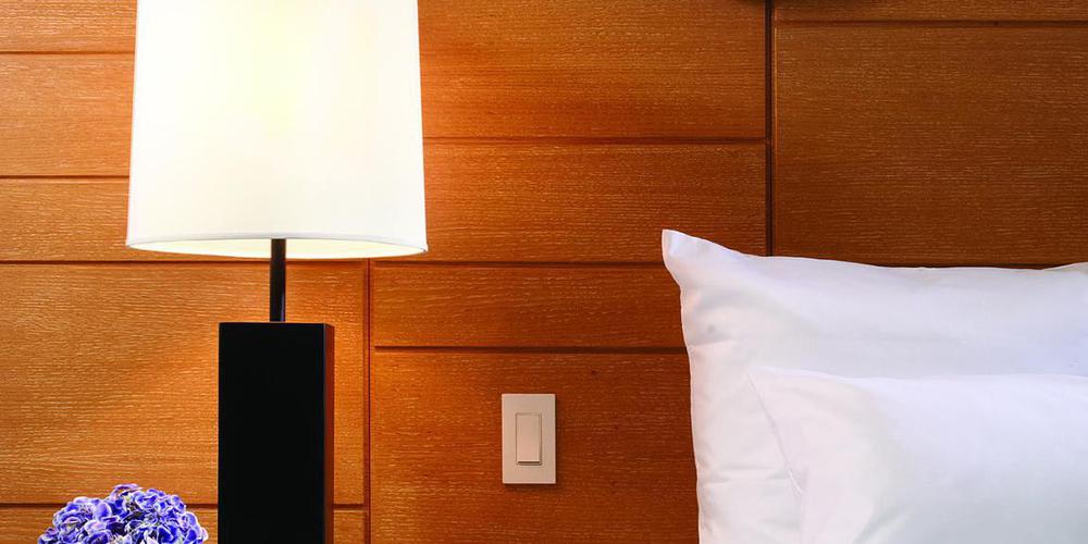 a lamp next to a bed