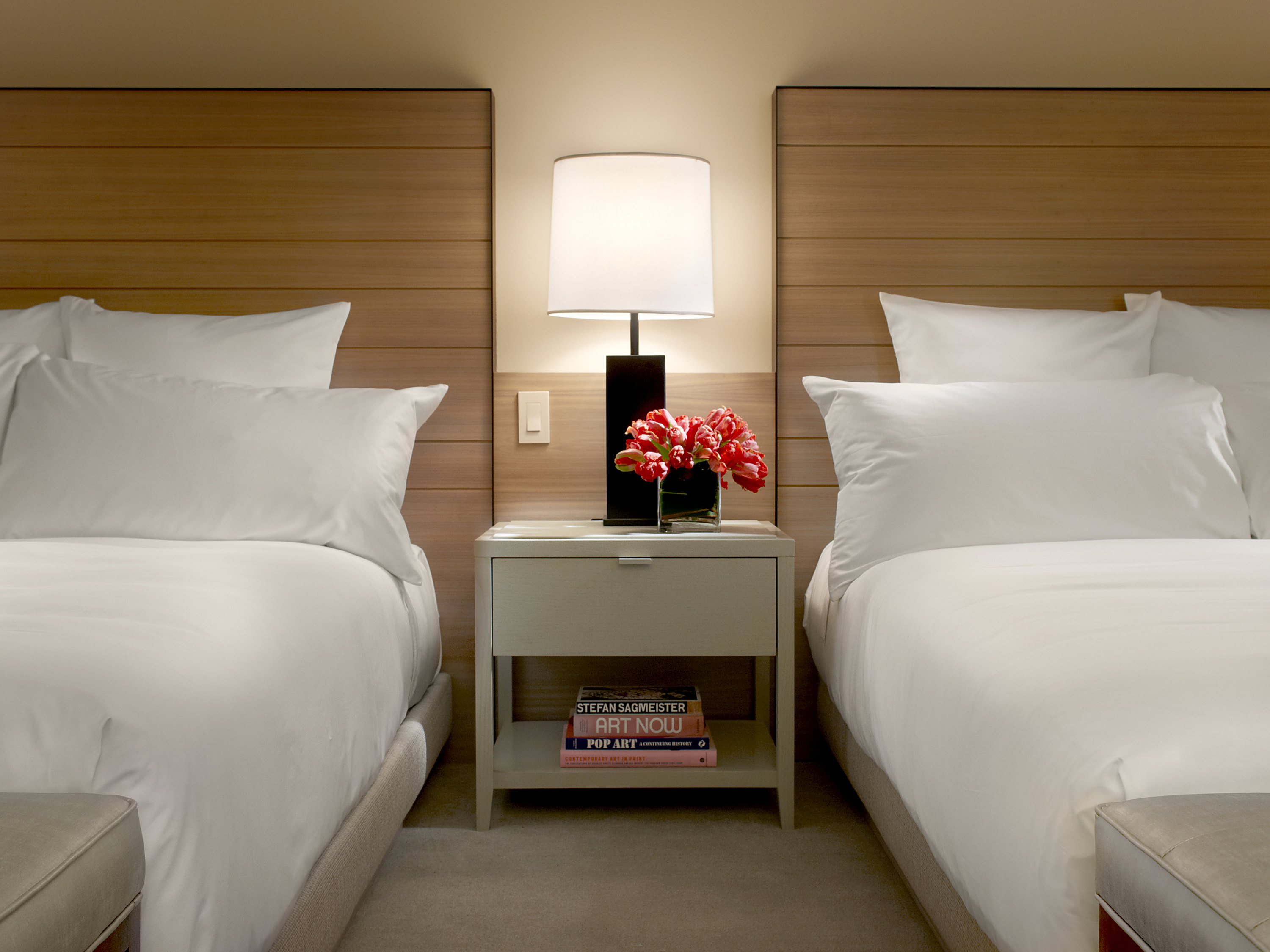 a bed with white pillows and a lamp on the side table