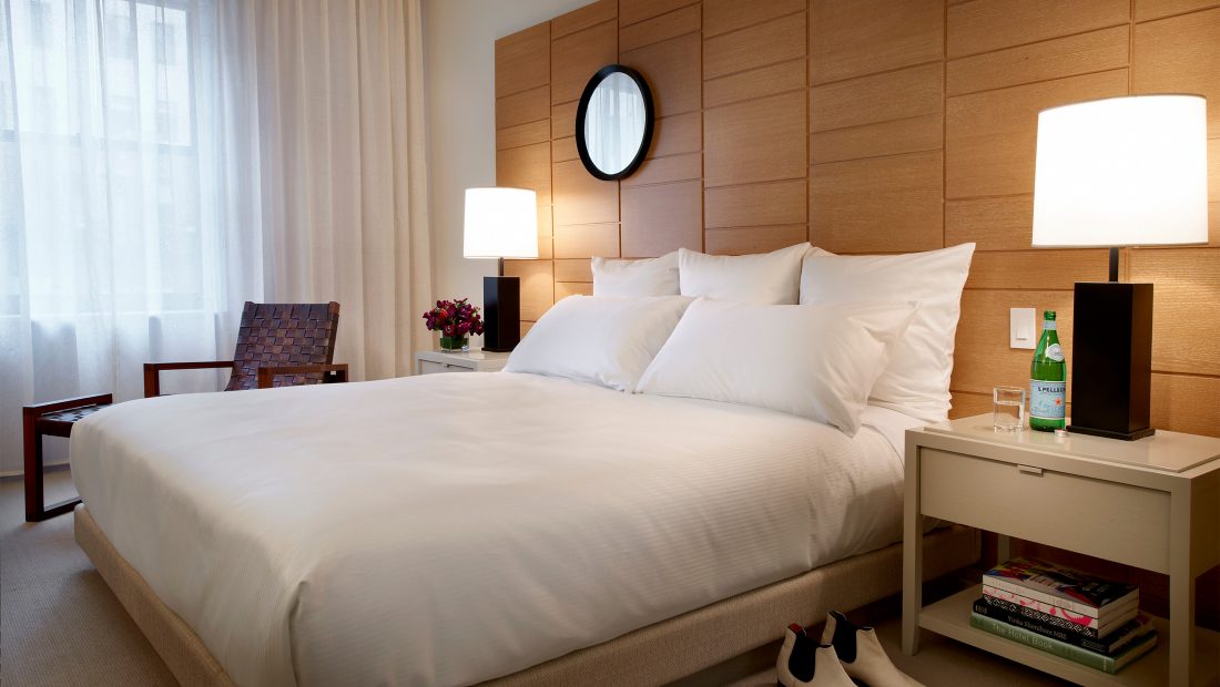 a bed with white sheets and a lamp