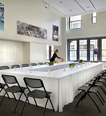 a woman standing in a room with a long table