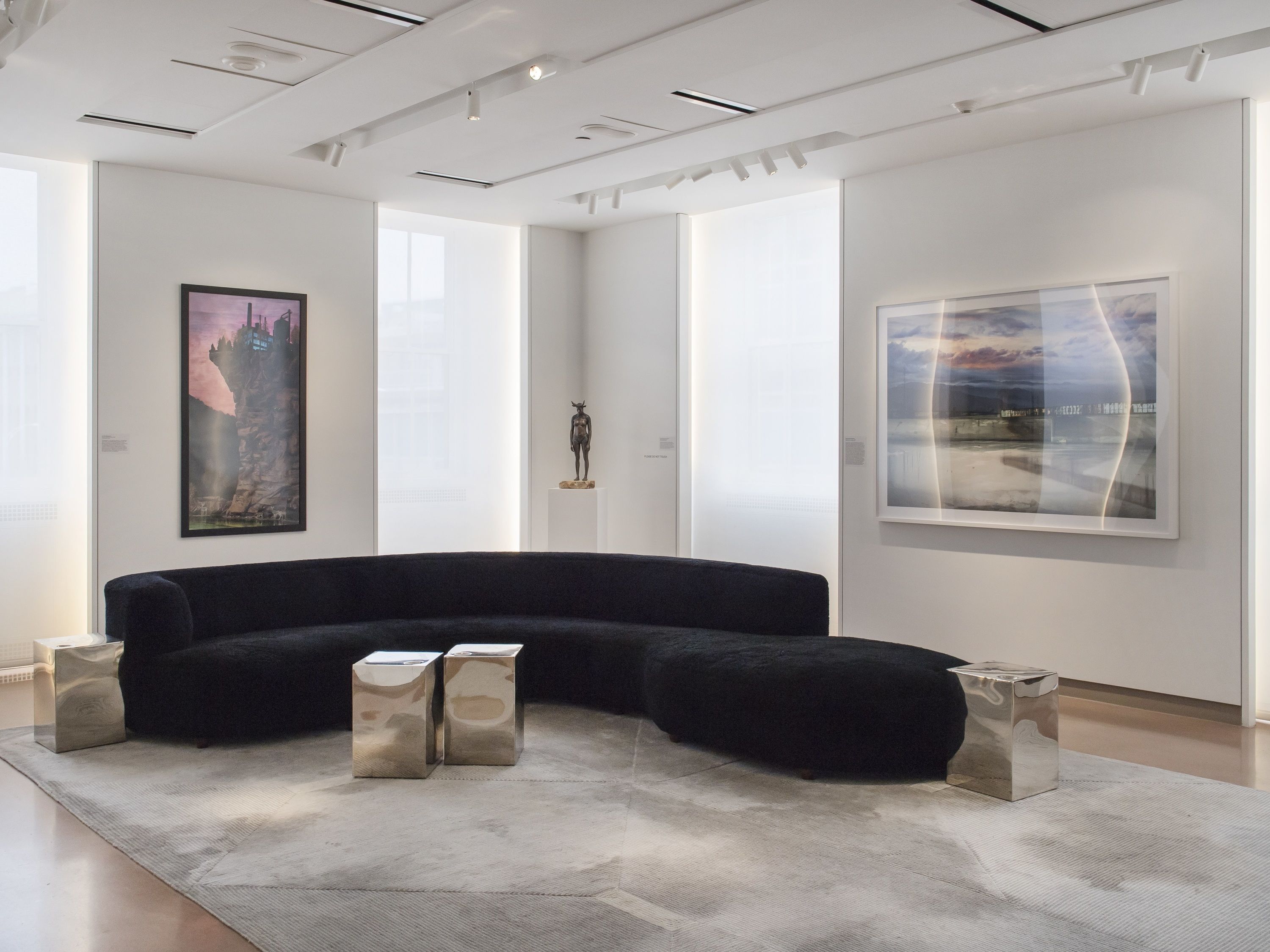 a large black couch in a room with art on the wall