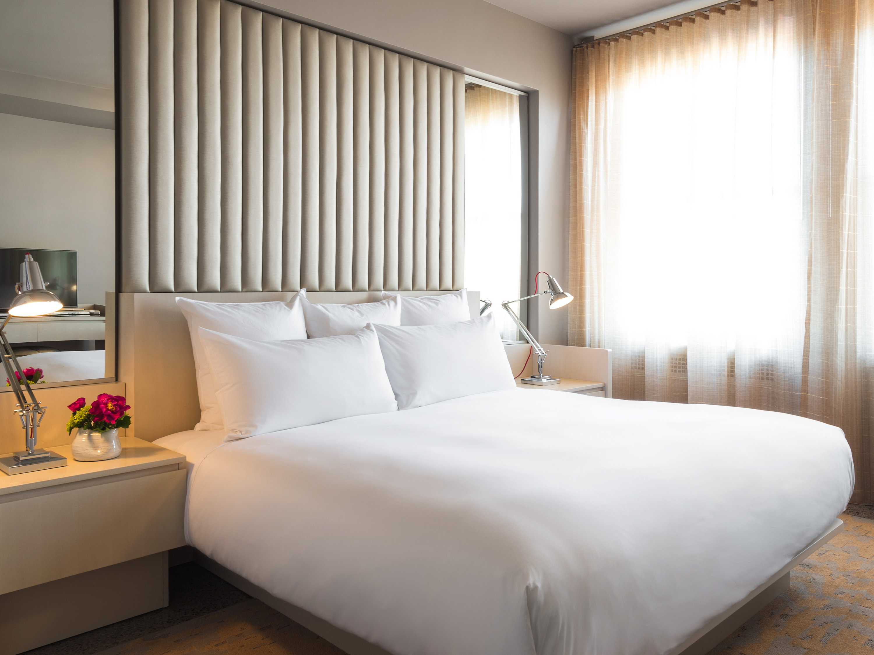 a bed with white sheets and a lamp