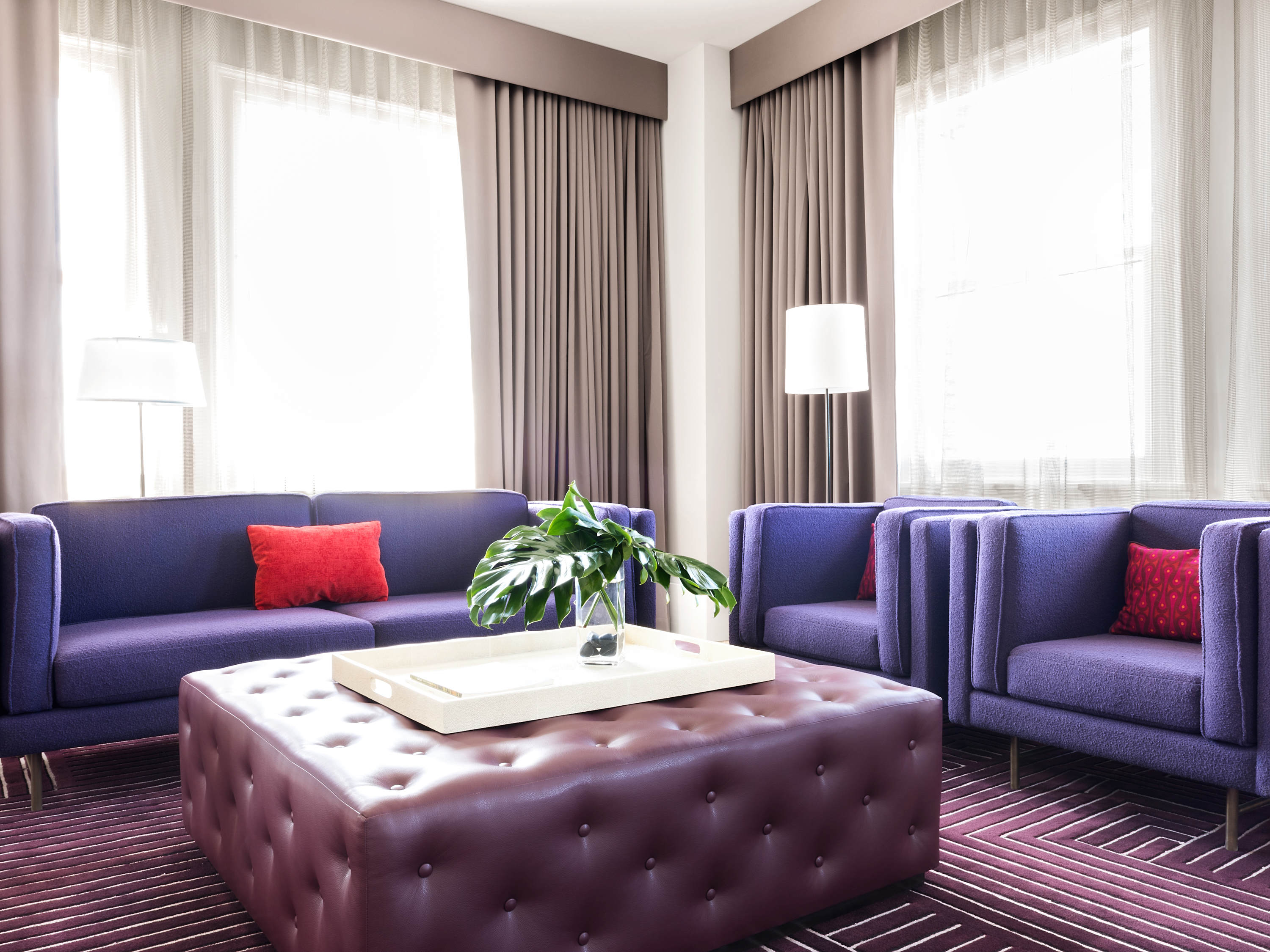 a room with purple furniture and a white square coffee table