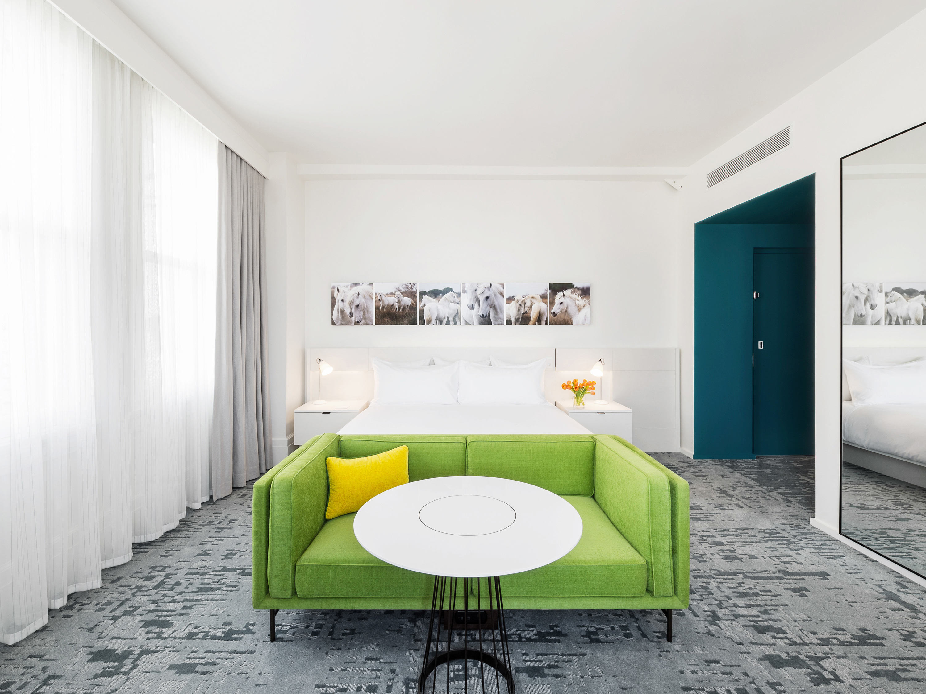 a room with a green couch and a white table