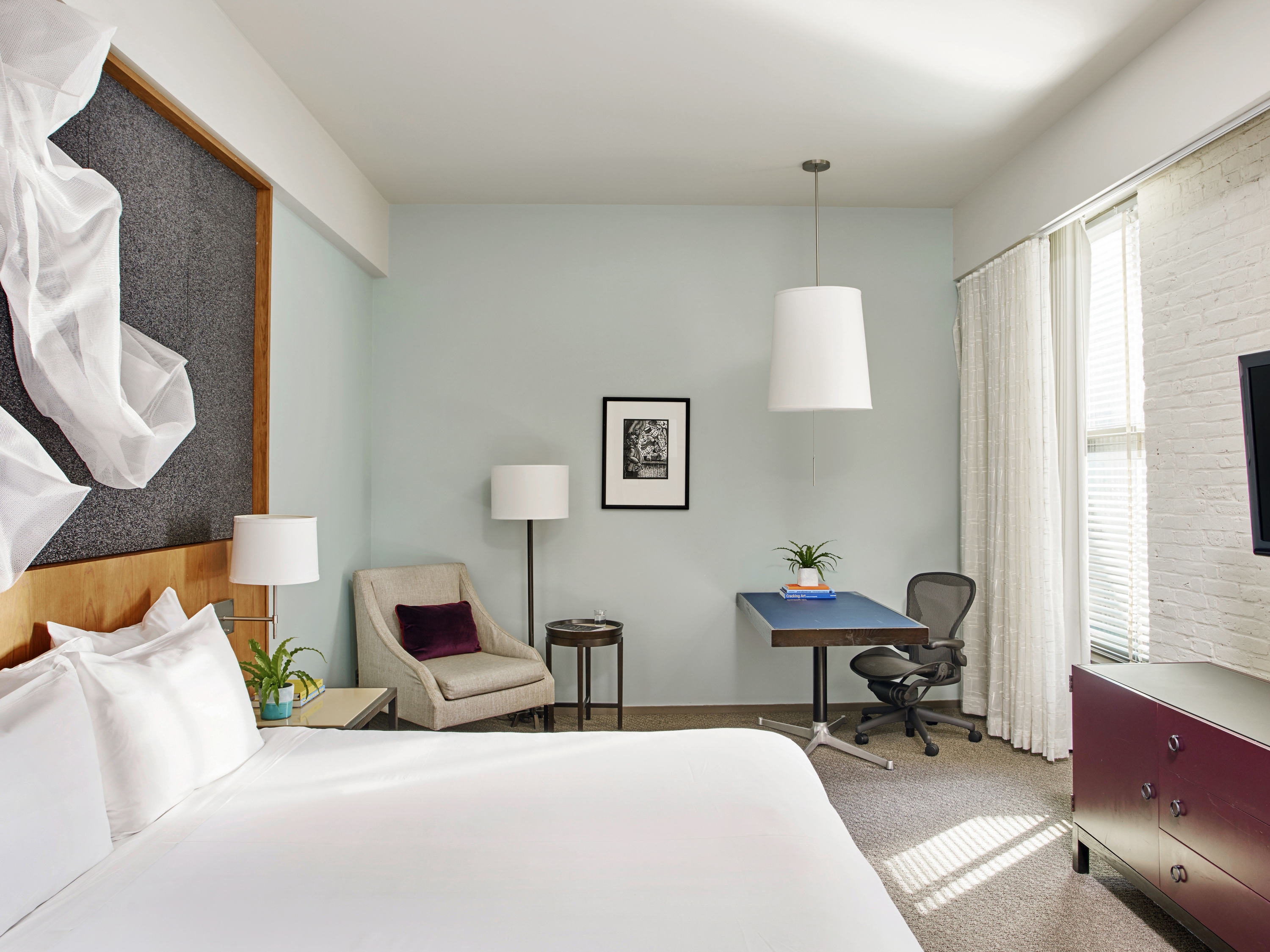 a room with a bed and a desk and chairs