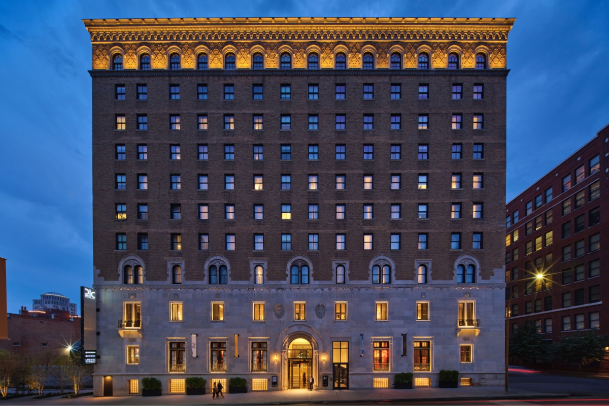 a building with many windows and a man walking in front of it