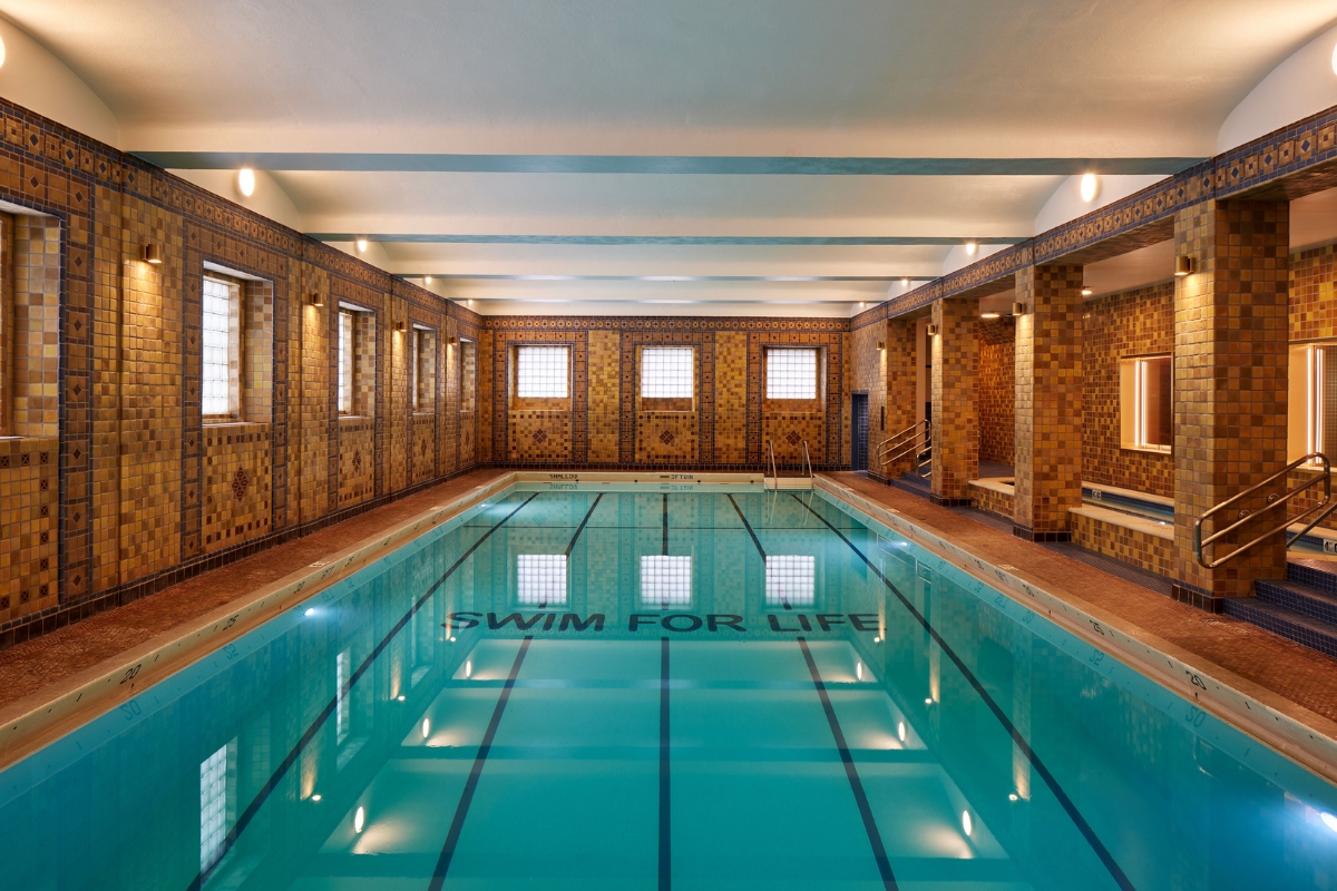 a indoor swimming pool with a tiled wall