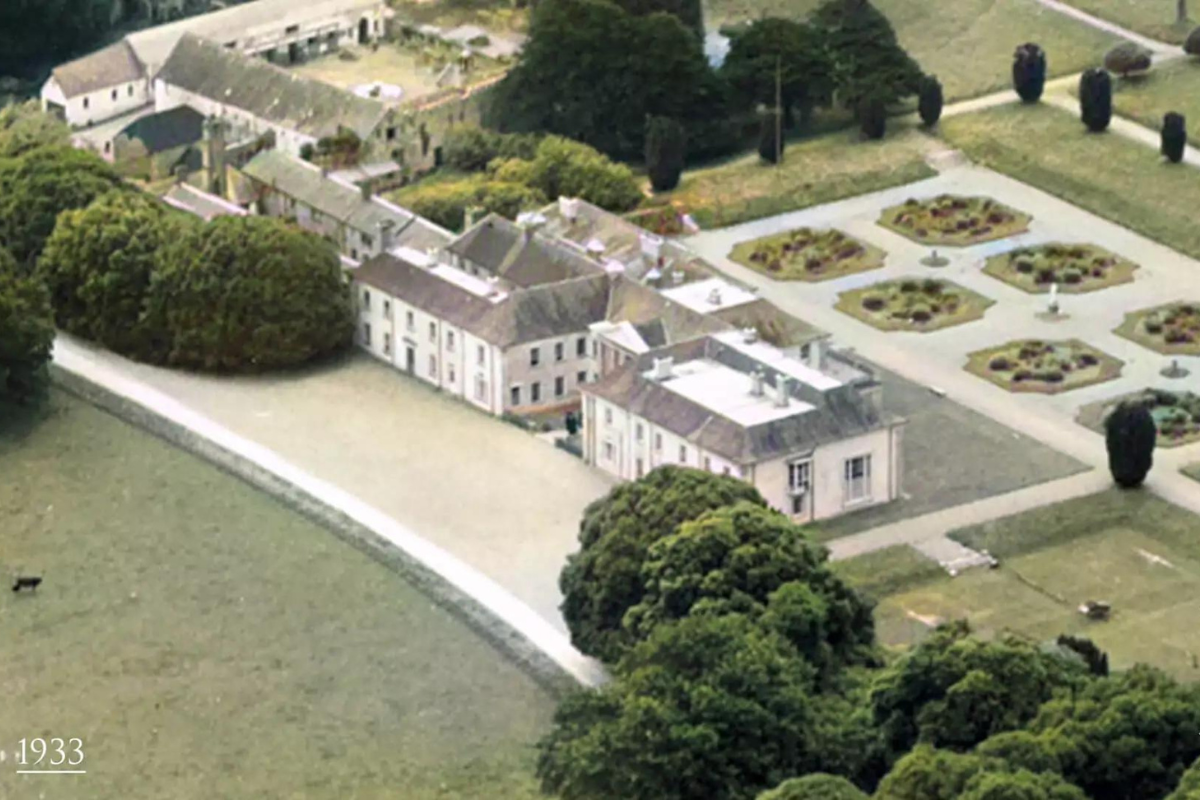 a large building with a garden and trees