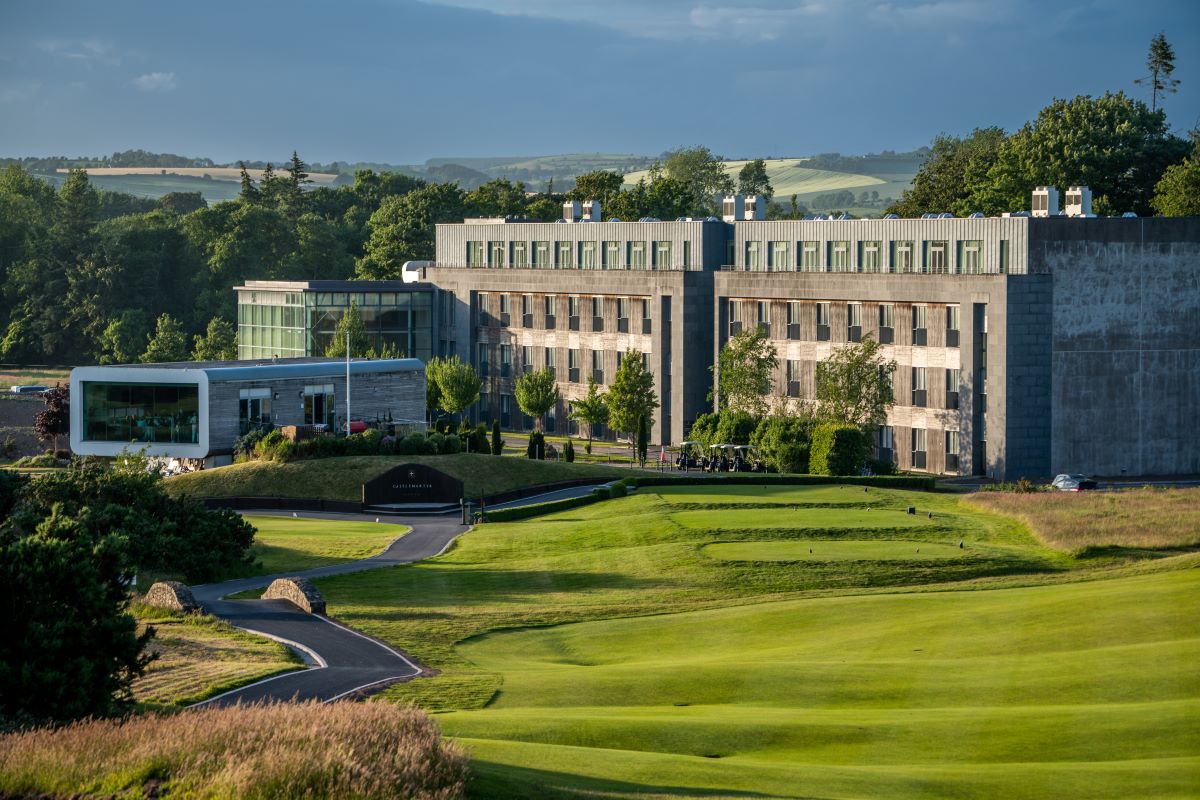 a building with a golf course and trees