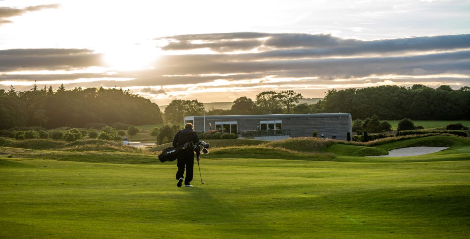 a person carrying a golf bag
