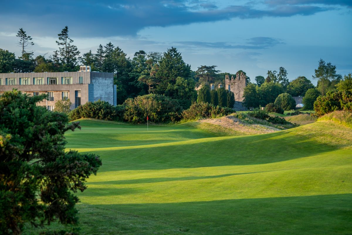 a golf course with a building and trees