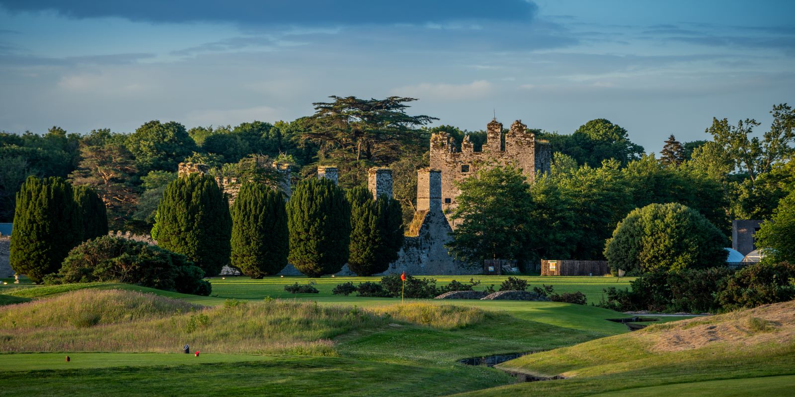 a golf course with a castle and trees