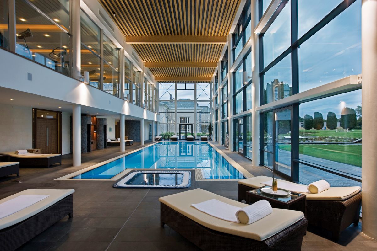 a indoor swimming pool with chairs and a large pool