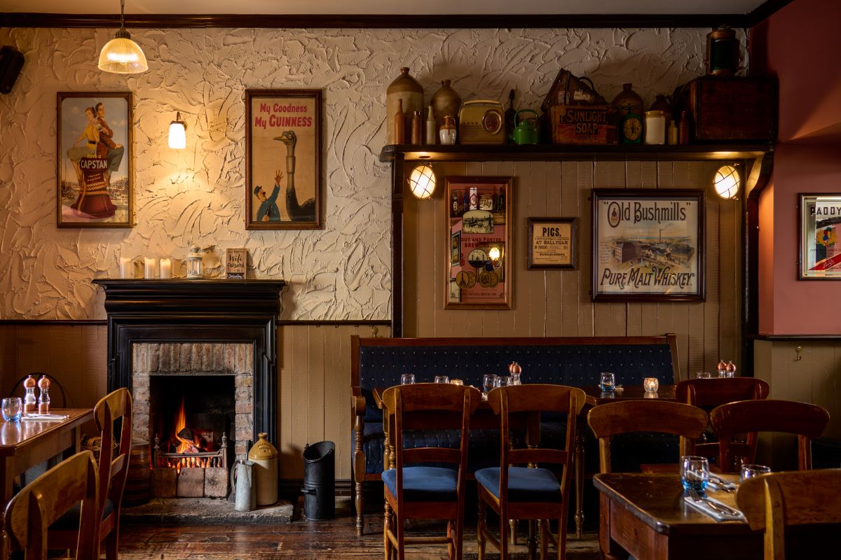 a room with a fireplace and tables and chairs