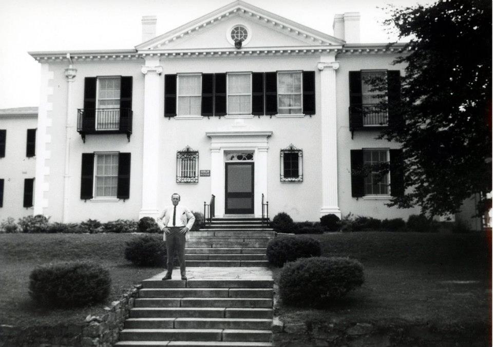 a man standing in front of a white house