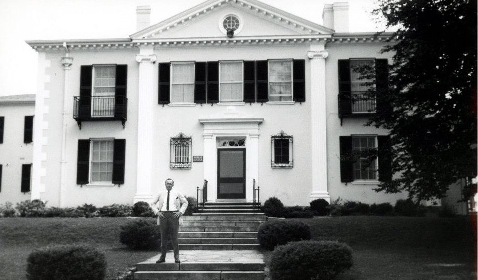 a man standing in front of a white house