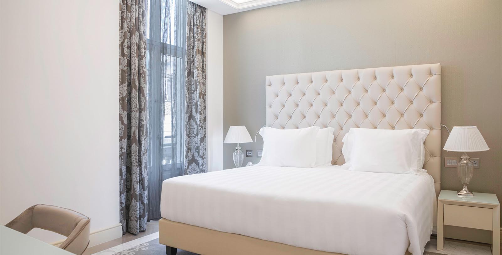 a bed with white sheets and pillows in a room