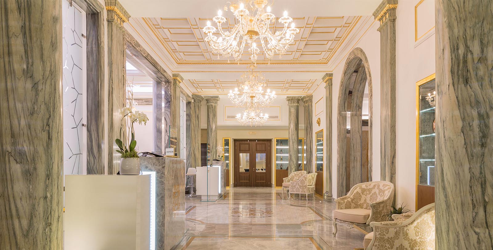 a lobby with chandeliers and marble floor