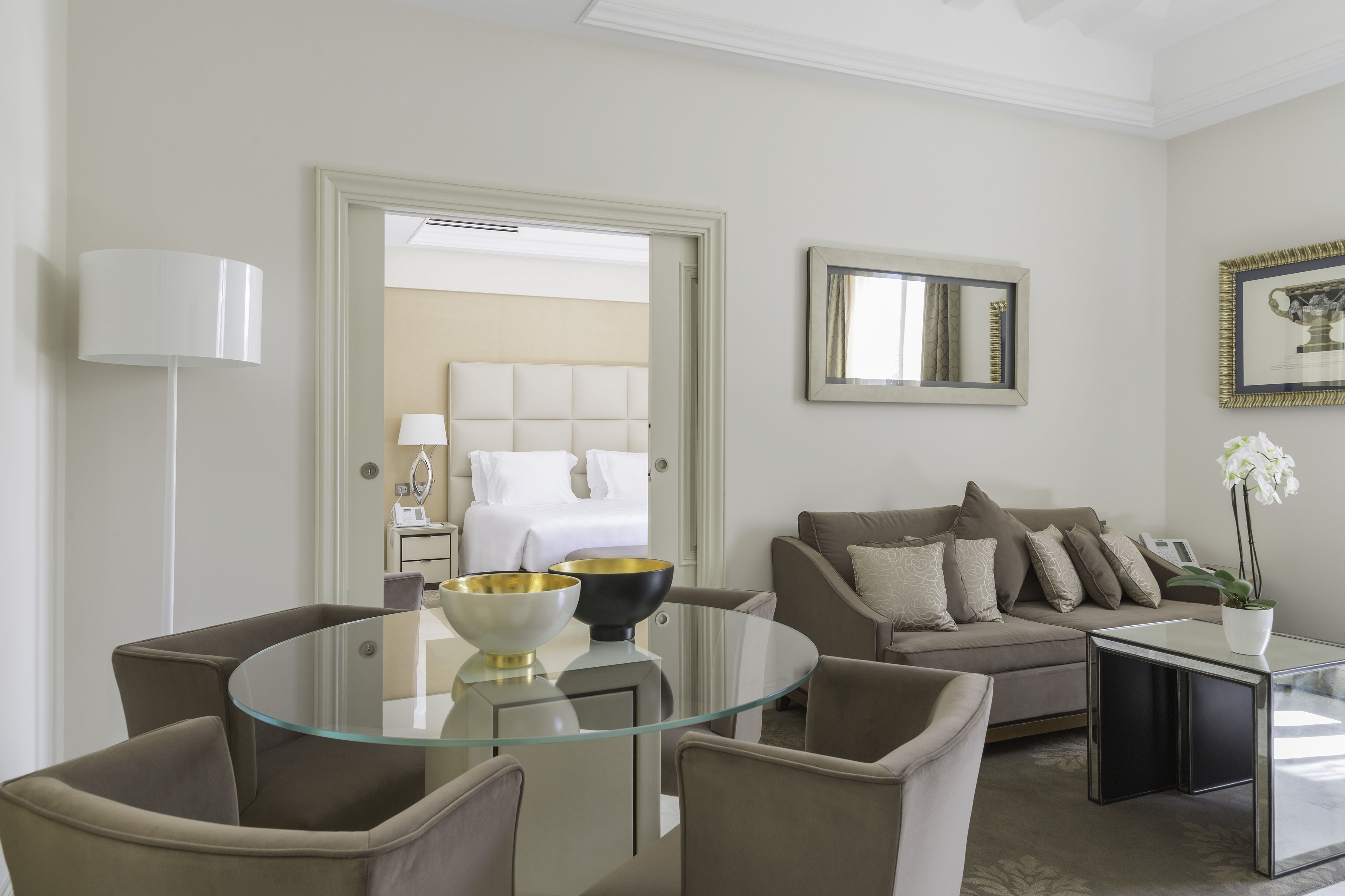 a room with a glass table and couches