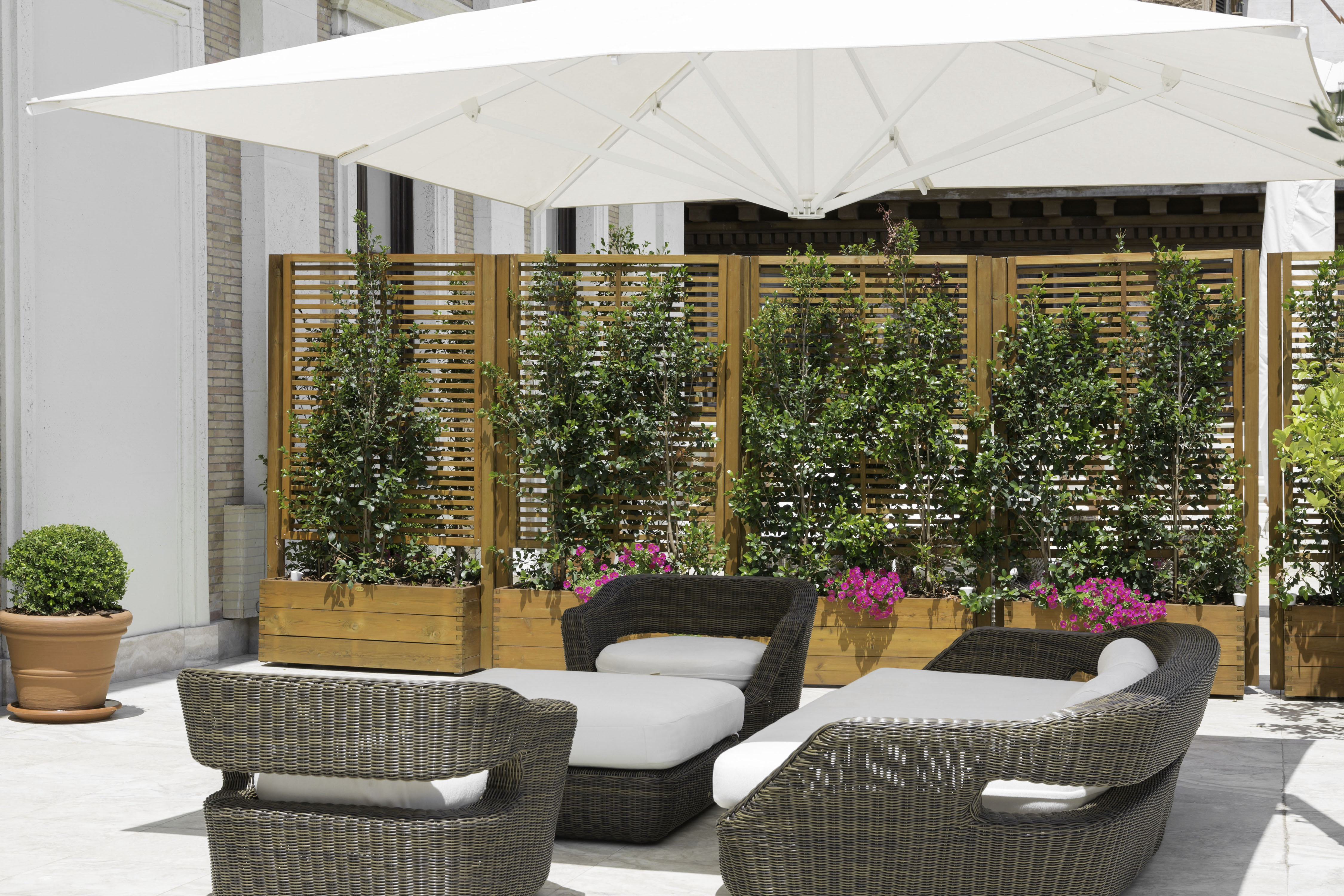 a patio with chairs and a white umbrella