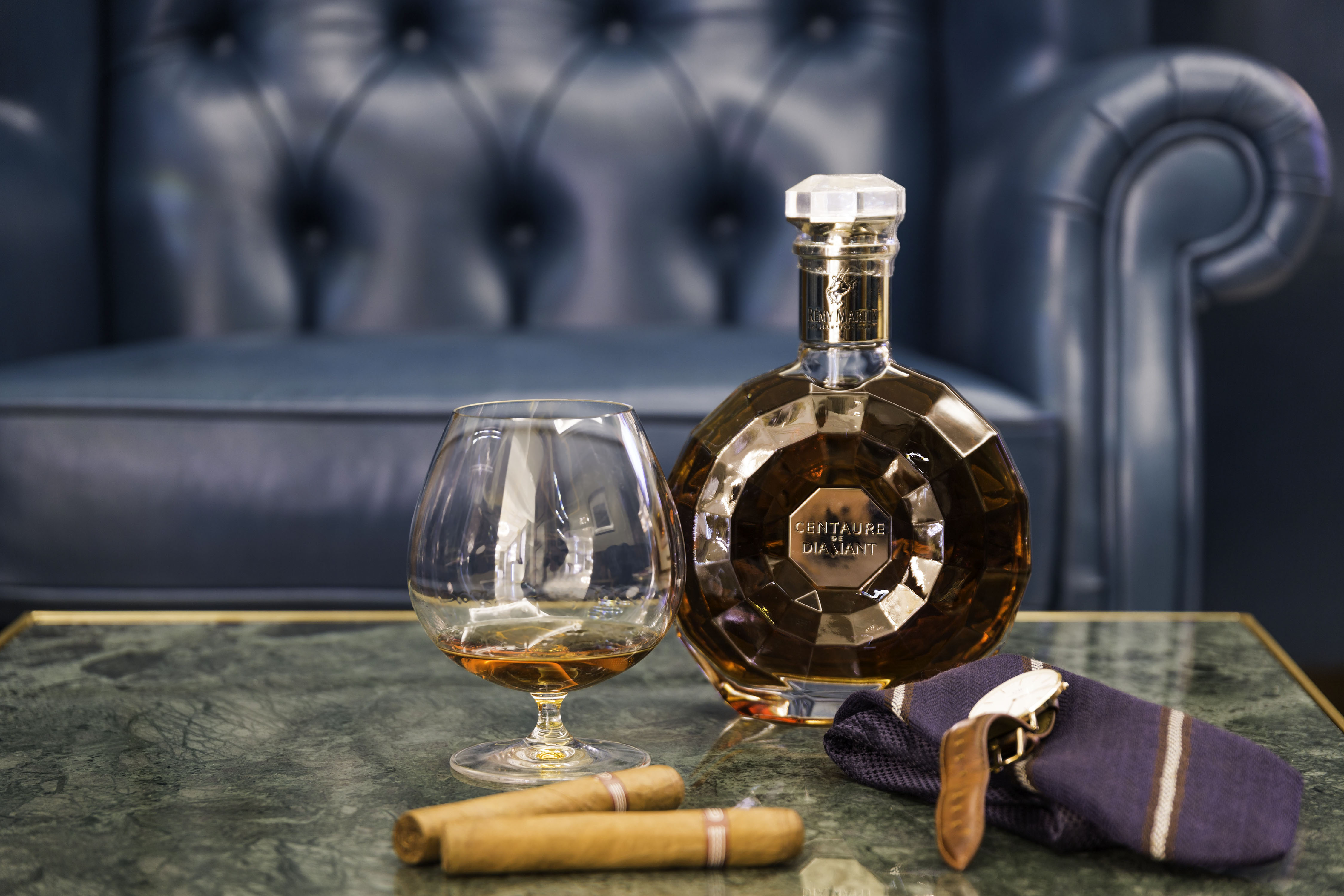 a bottle of alcohol and cigar on a table