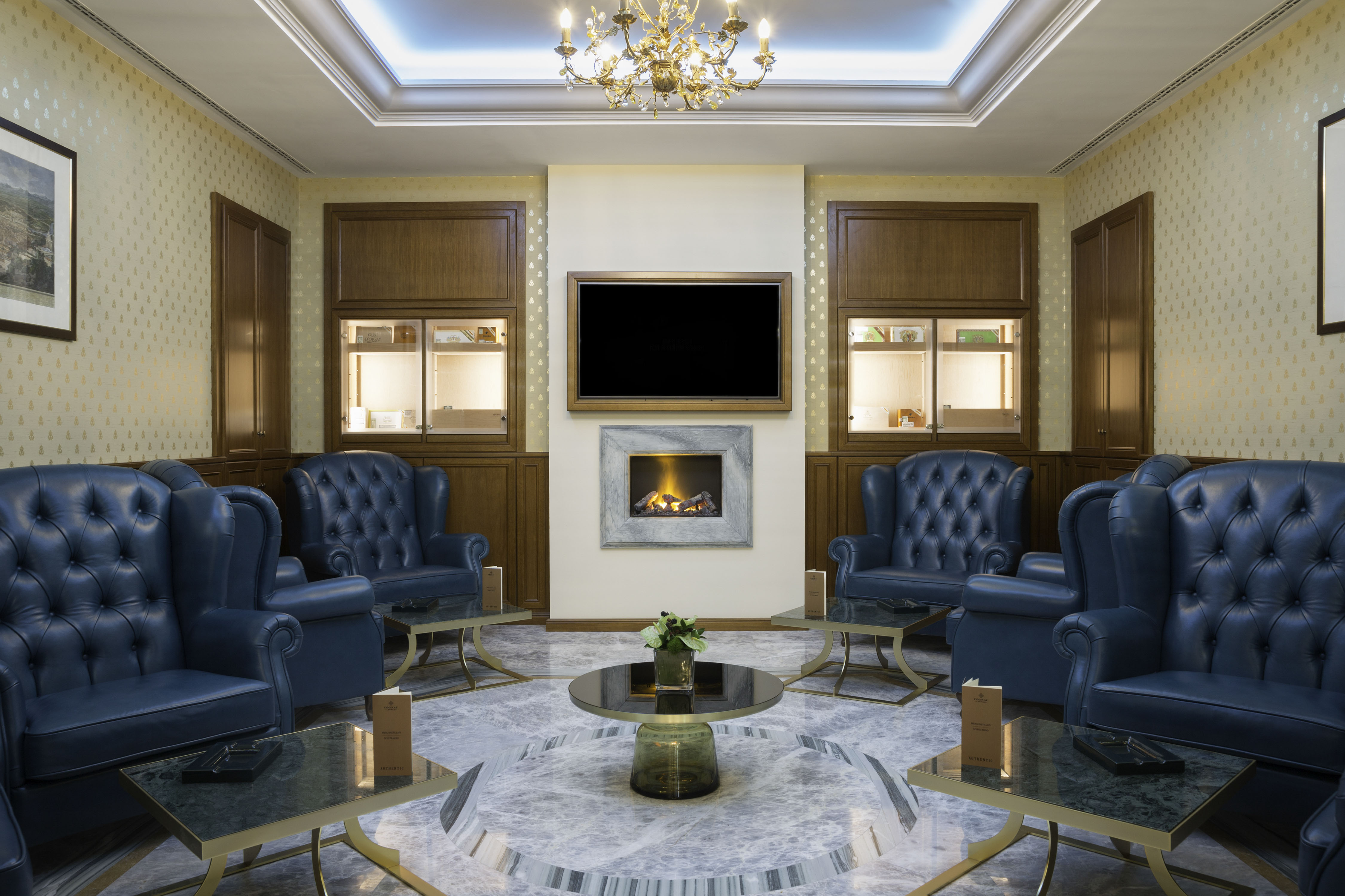 a room with a fireplace and blue chairs