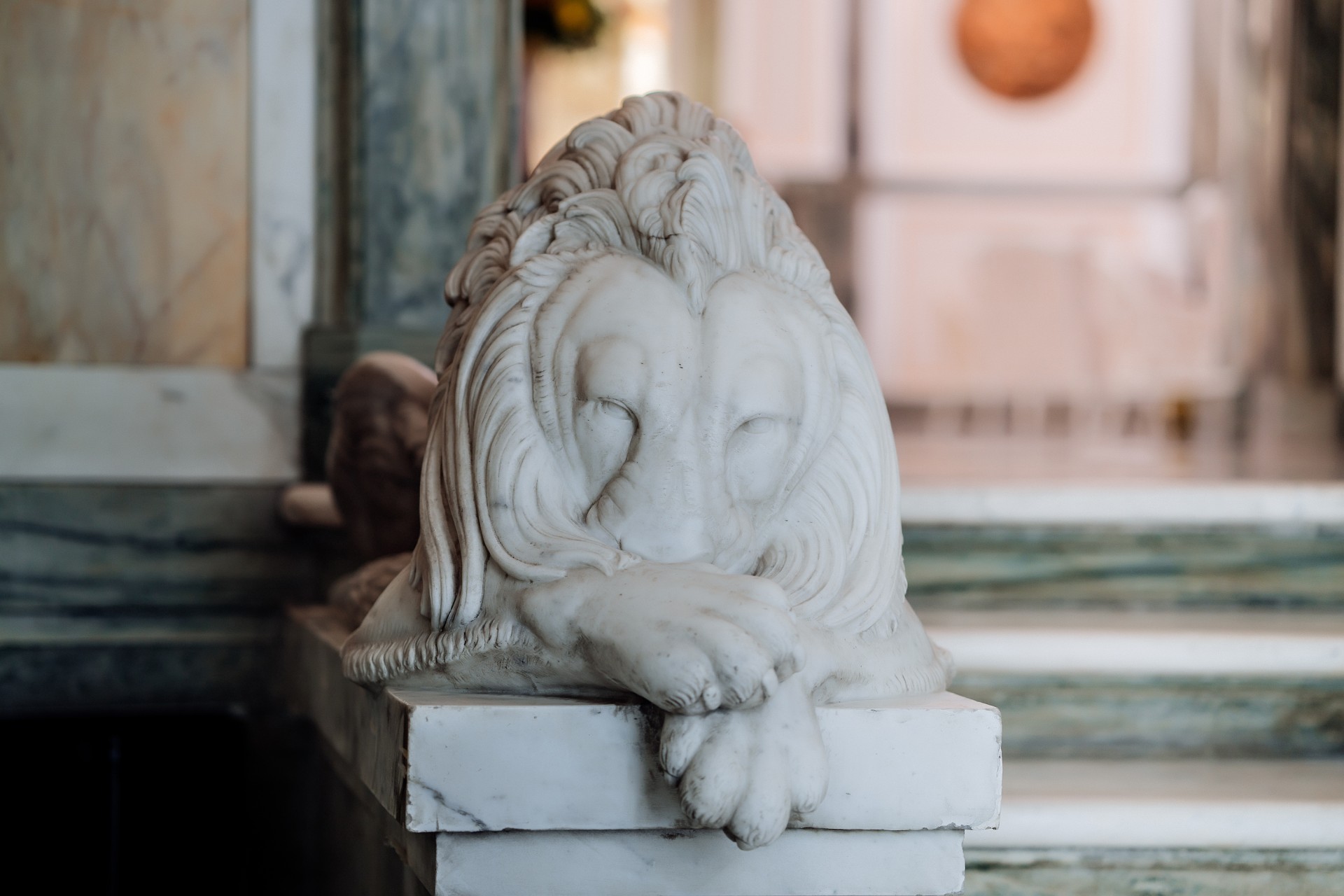 a statue of a lion with its head on a ledge