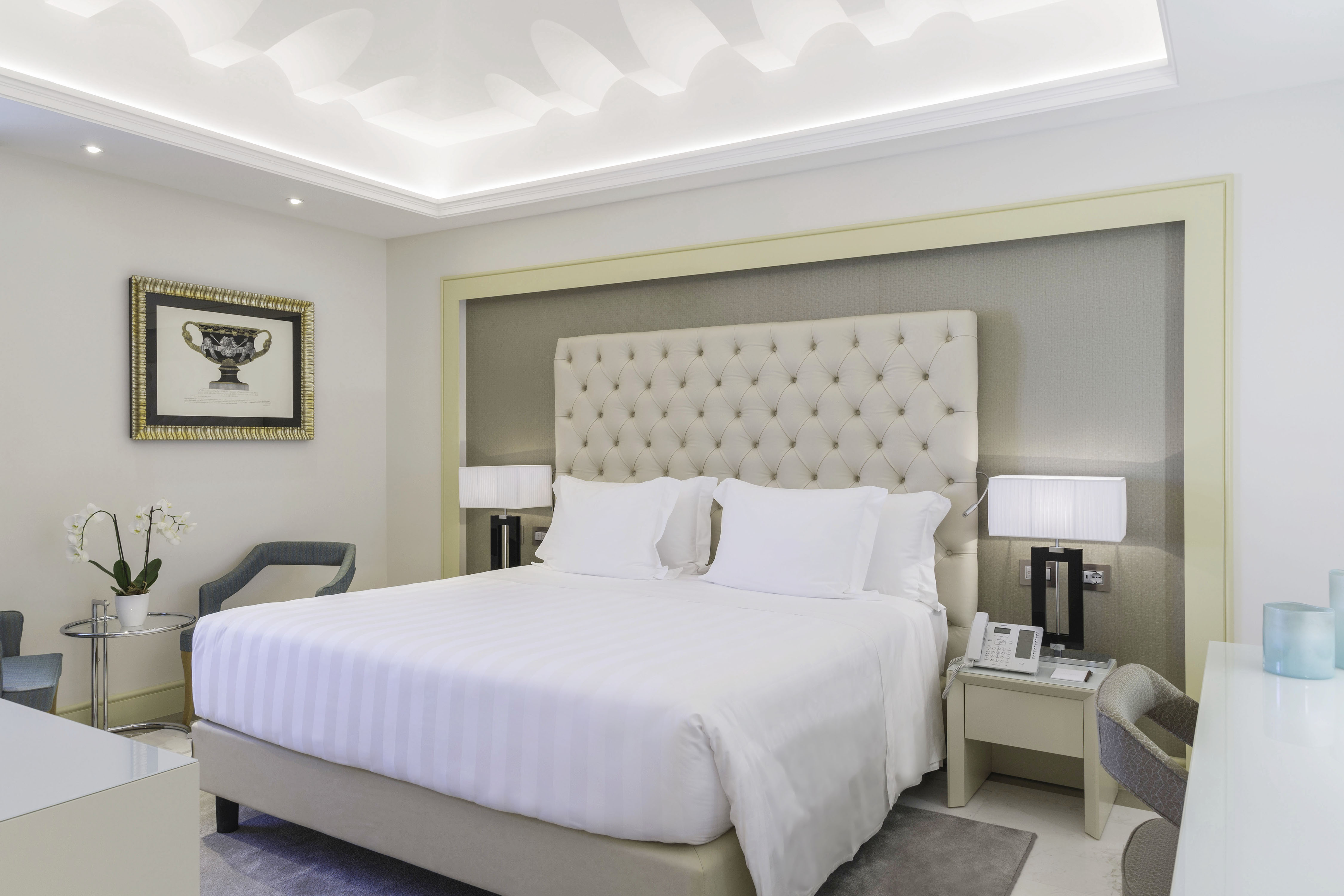a bed with white sheets and pillows in a room