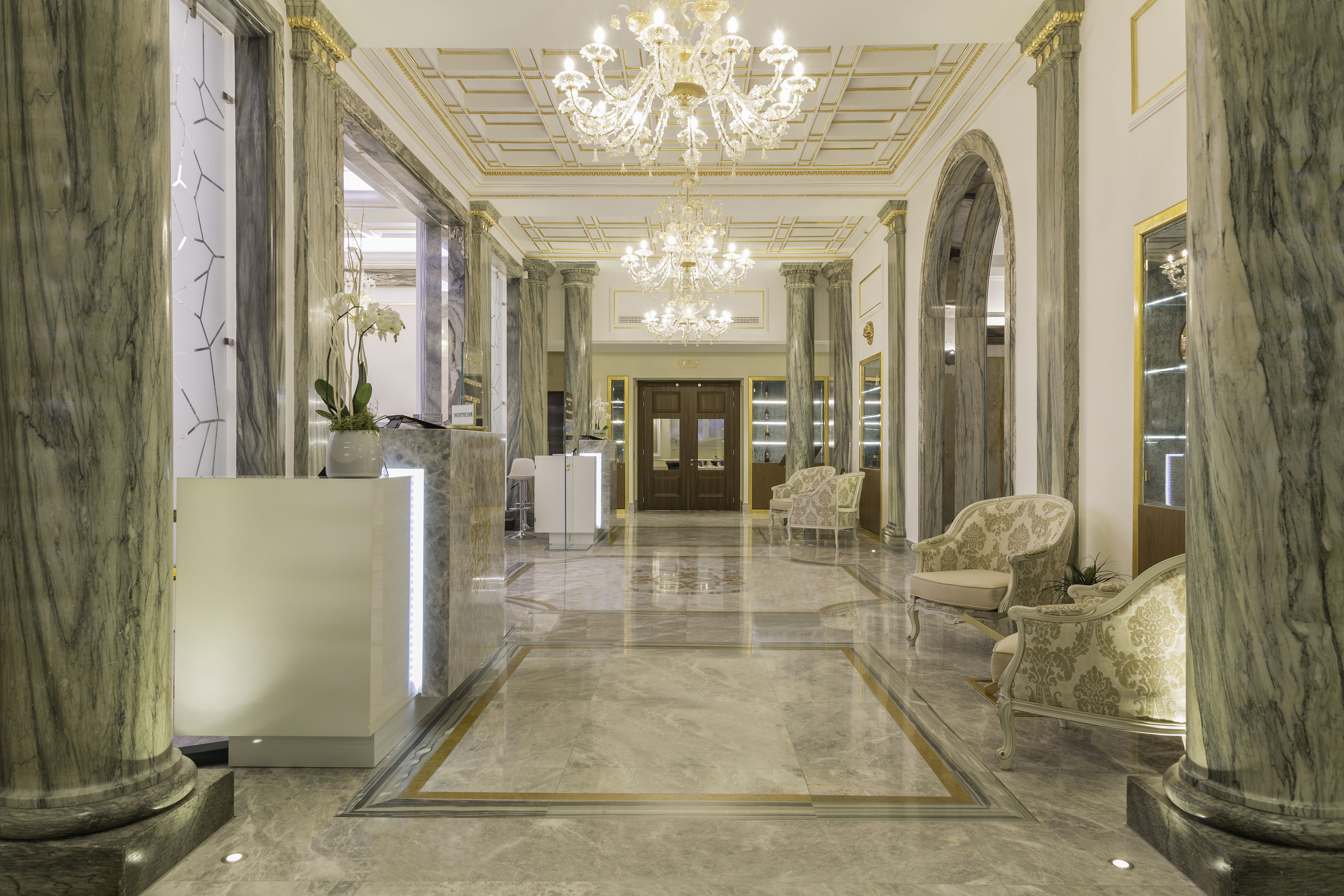 a lobby with marble floor and chandelier