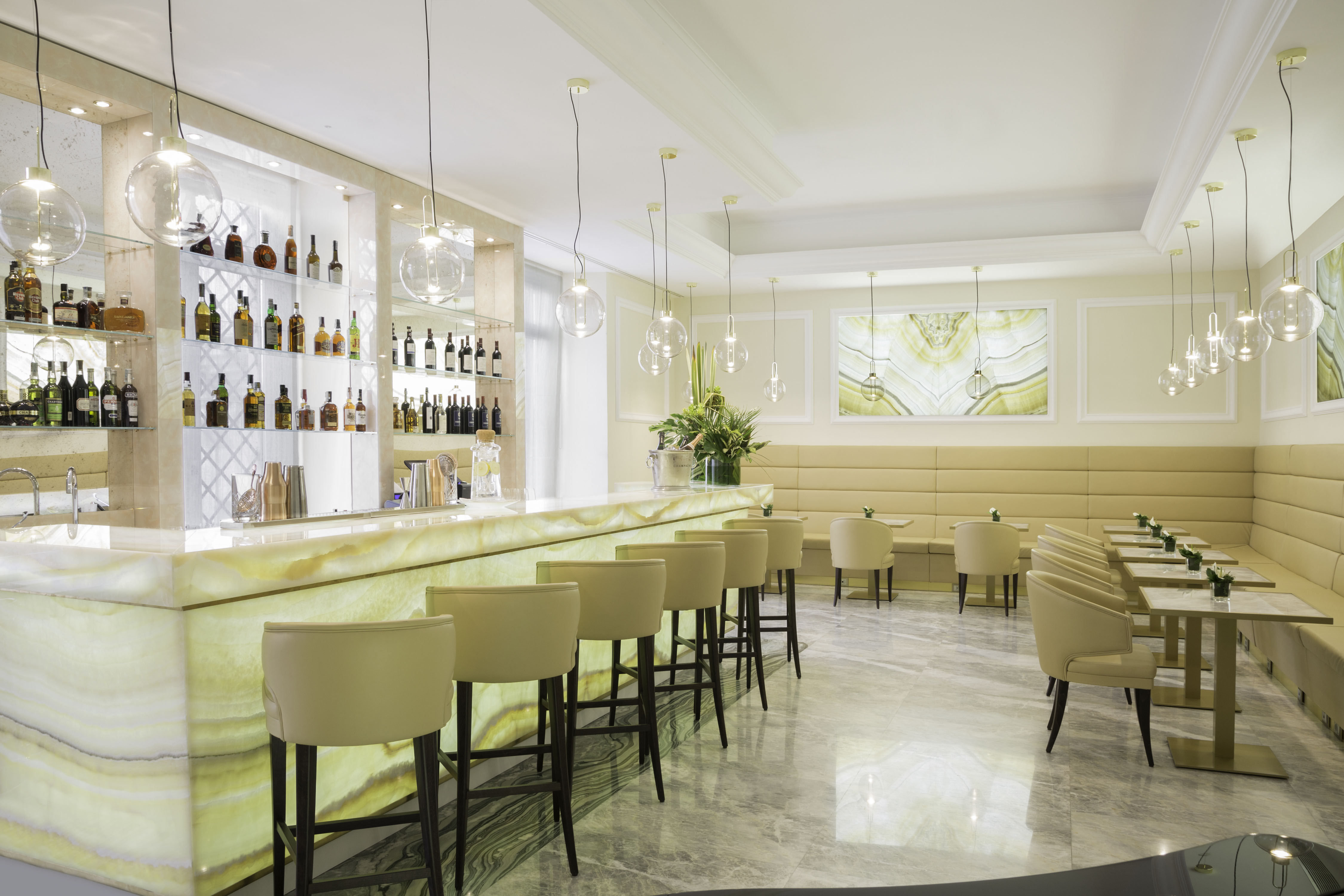 a bar with chairs and a shelf with bottles