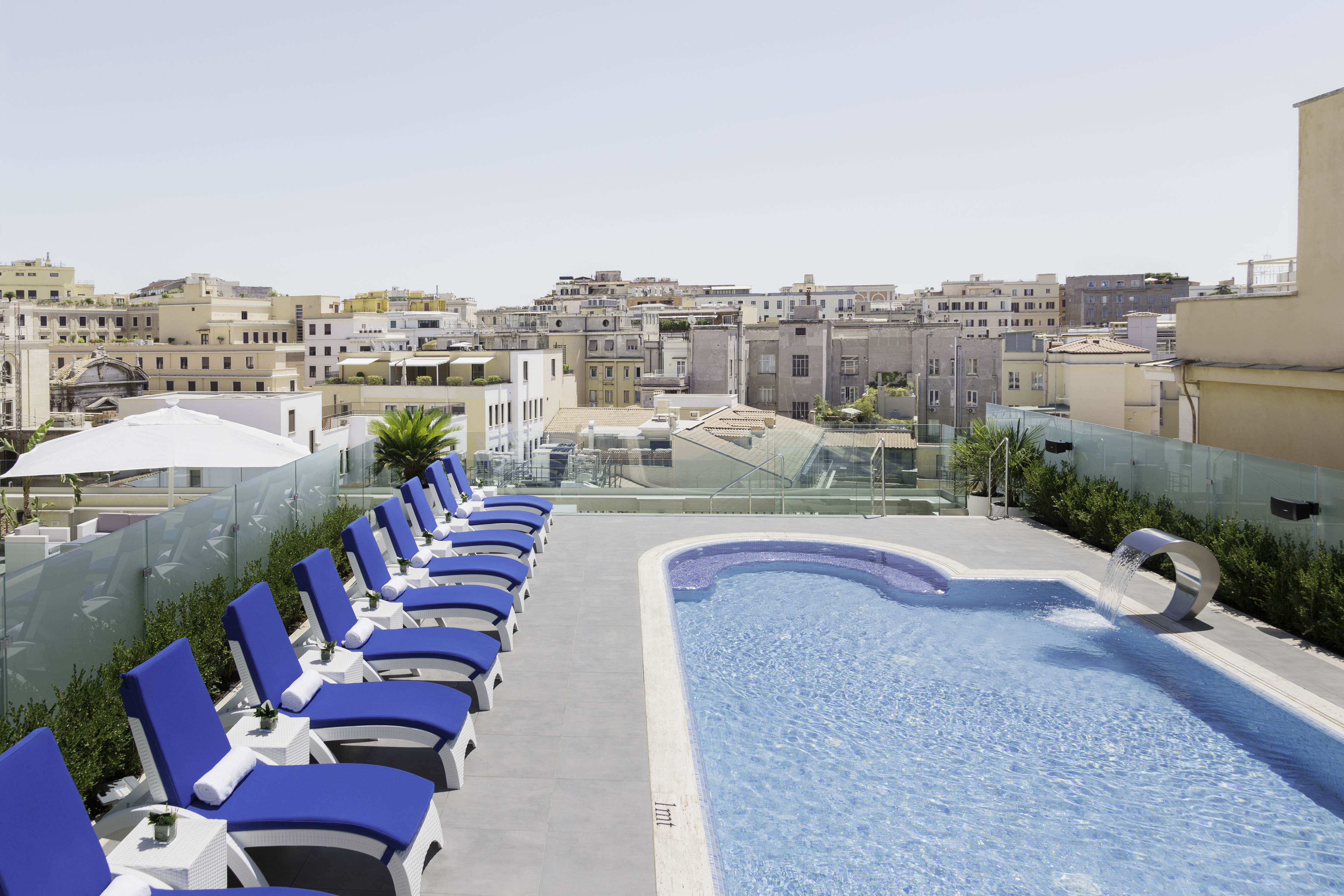 a pool with chairs and a pool in the background