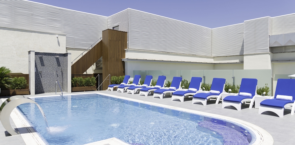 a pool with chairs and a building