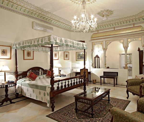 a bedroom with a four poster bed and a chandelier