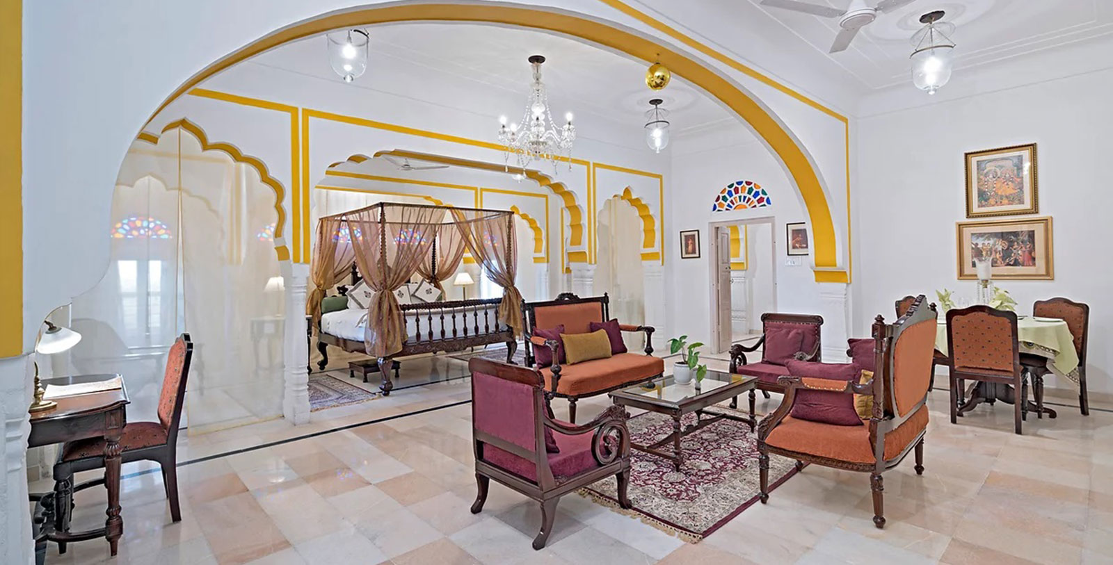 a room with a bed and chairs