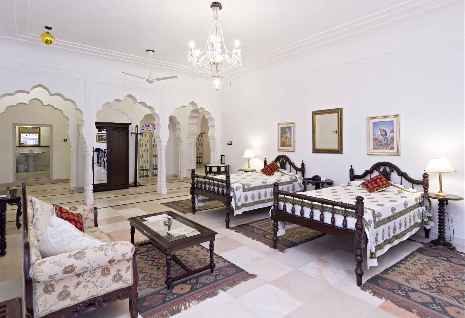 a room with two beds and a chandelier