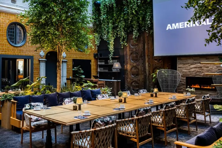 a large table with chairs and a projector screen