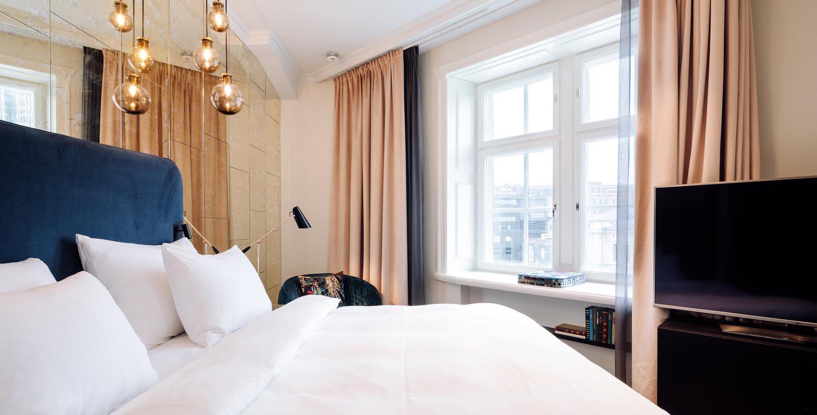 a bed with a white bedding and a lamp