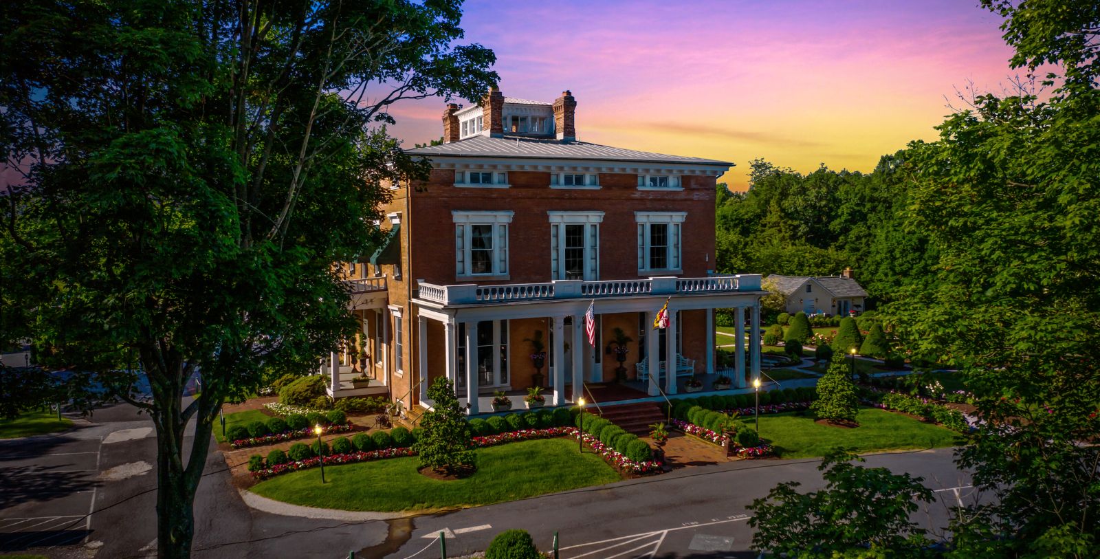 a large brick house with a large lawn and trees