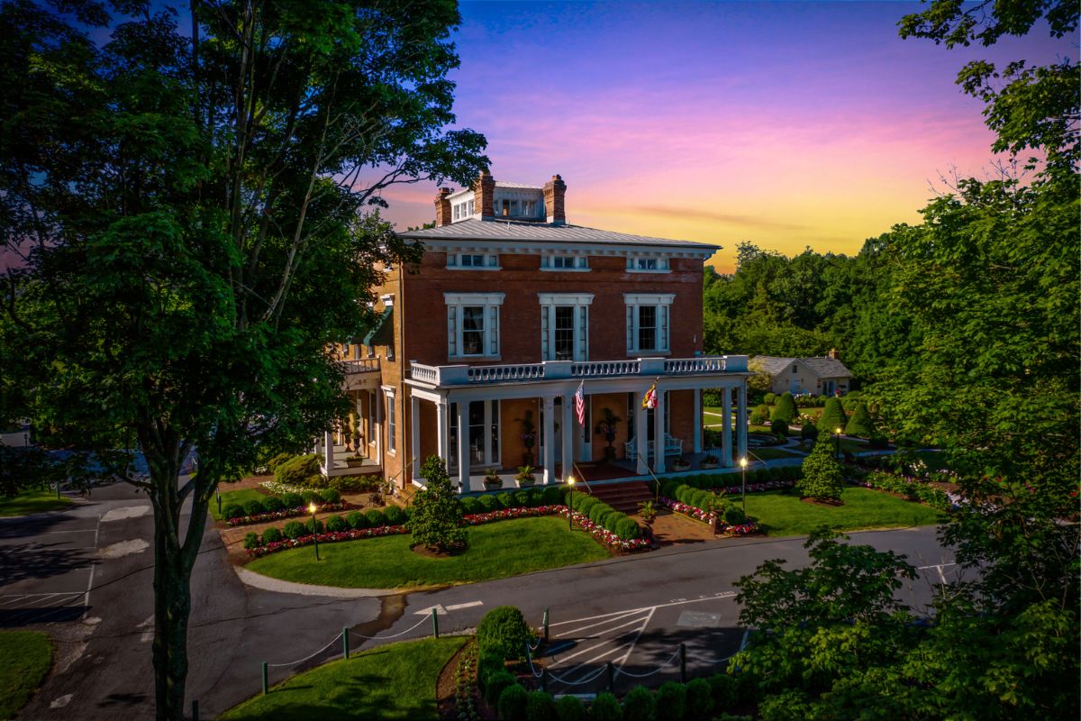 a large brick house with a large front porch and a driveway