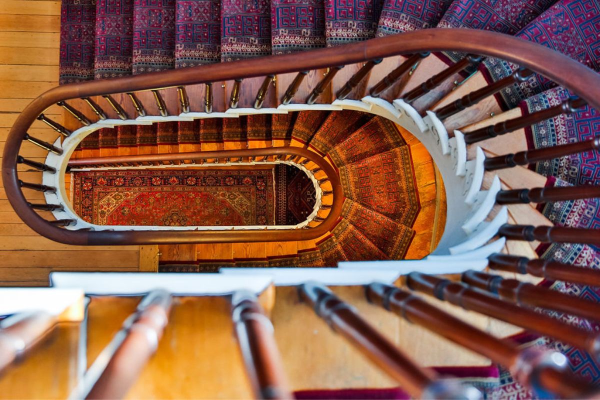 a spiral staircase with a rug on the floor