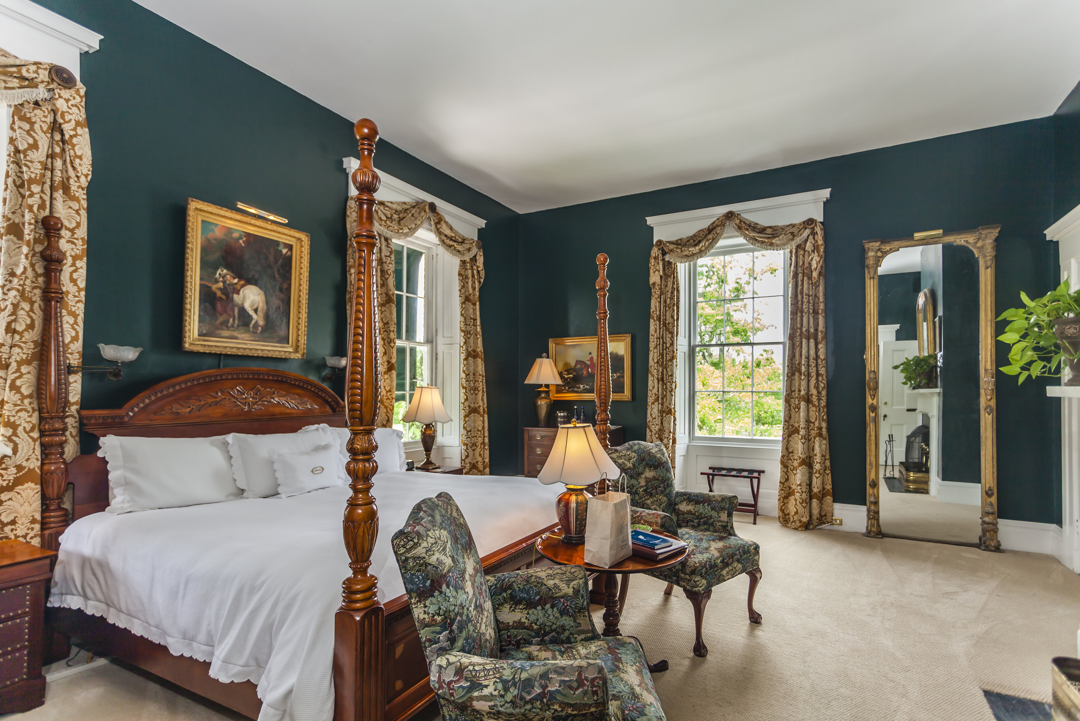 a bedroom with a four poster bed and chairs