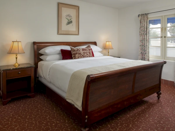 a bed with a wooden sleigh bed and two lamps