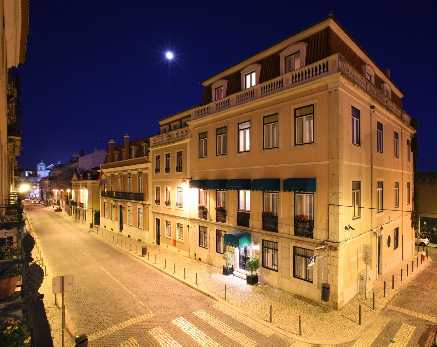a street with buildings and a street sign at night